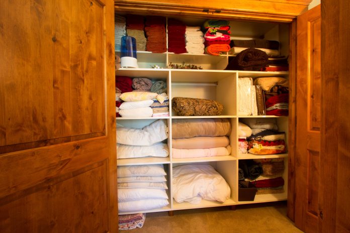 clean-organized-linen-closet-bedsheets-towels-storage